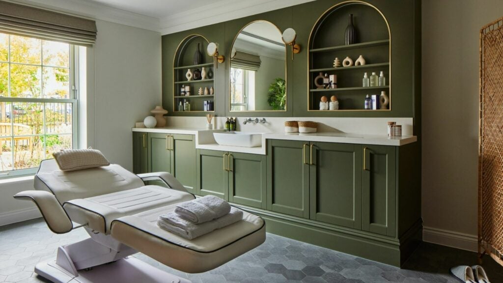 Elegant spa treatment room with green cabinetry.