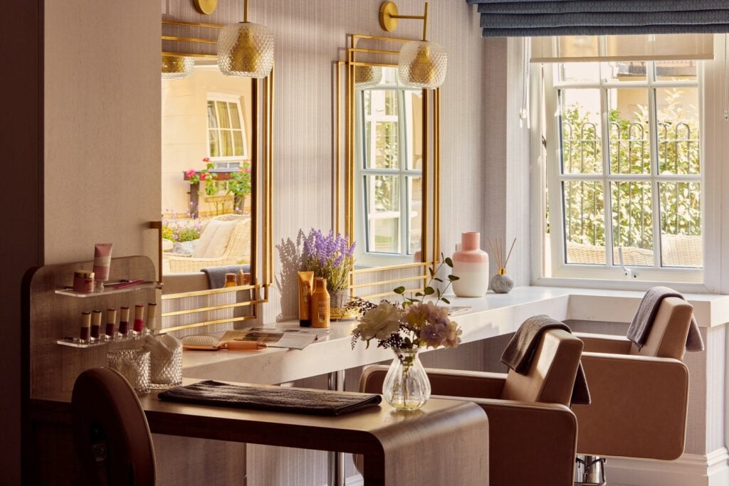 Elegant beauty salon interior with mirrors and flowers.