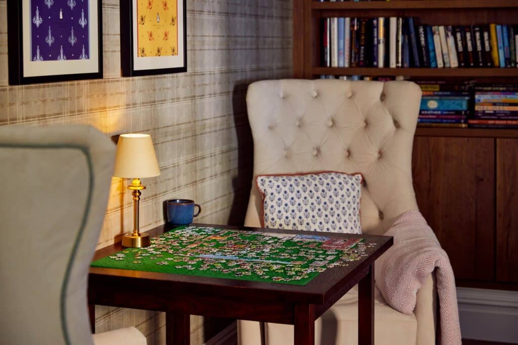 Cosy reading nook with puzzle and bookshelves.