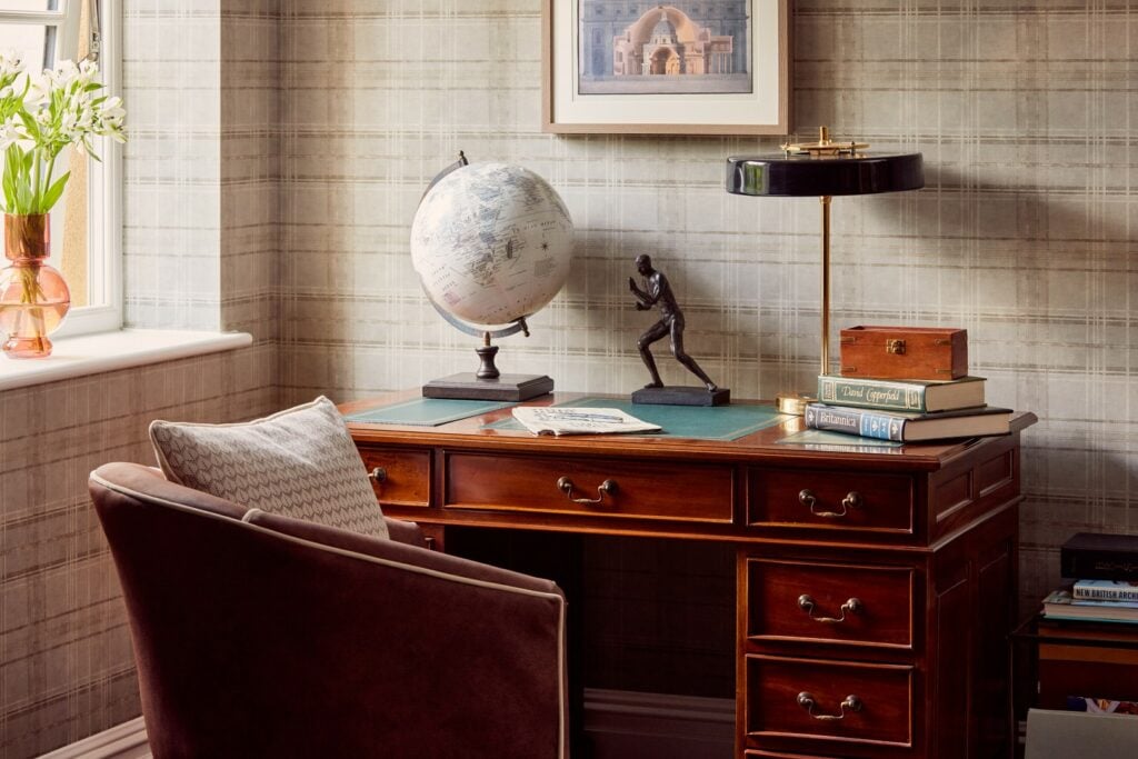 Elegant home office with wooden desk and comfortable chair.