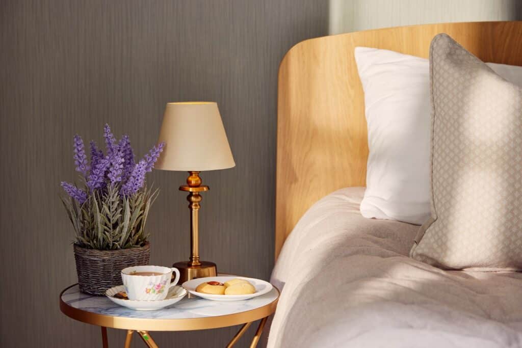 Cosy bed with tea, biscuits, and flowers