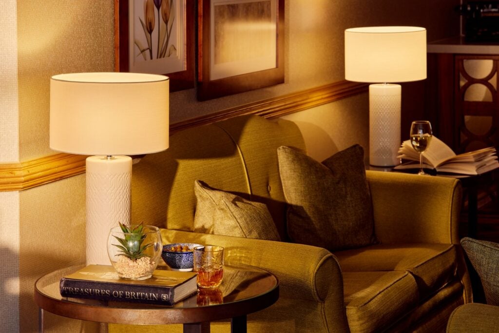 Cosy living room with lamps and armchair.
