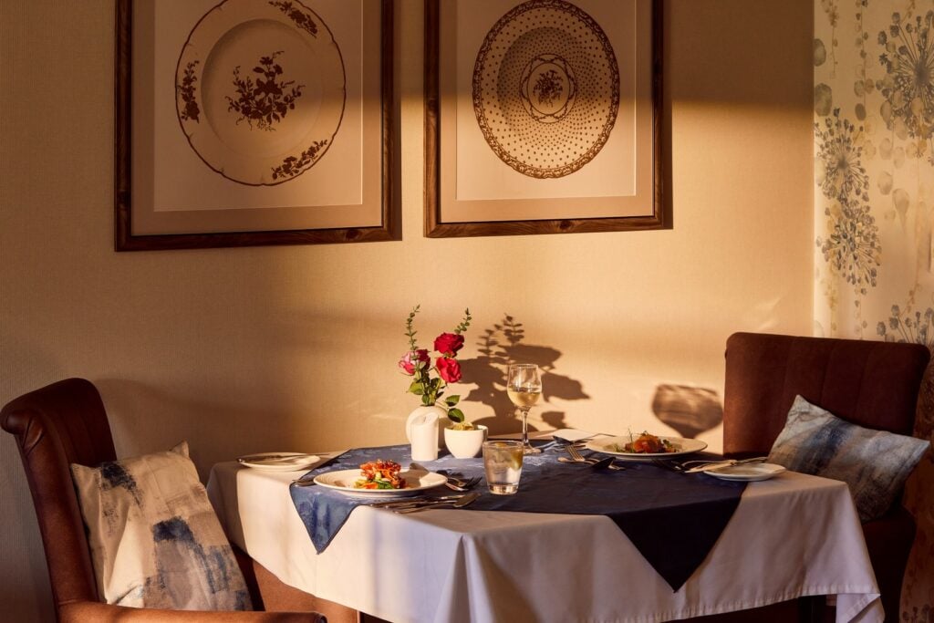 Cosy table for two with flowers in the dining room of Banstead Manor Care Home.
