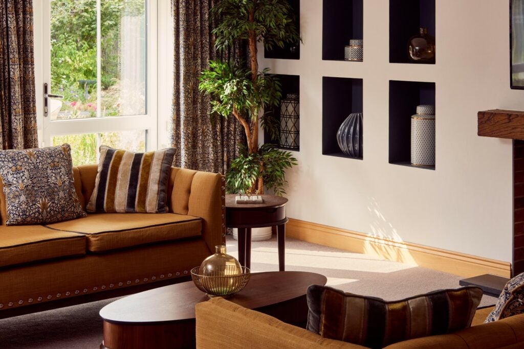 Cosy living room with sofa, cushions, and shelves
