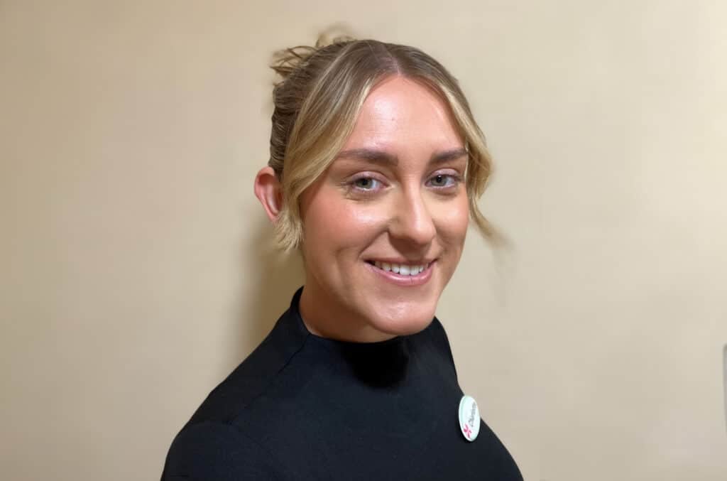 Smiling woman in black top with badge