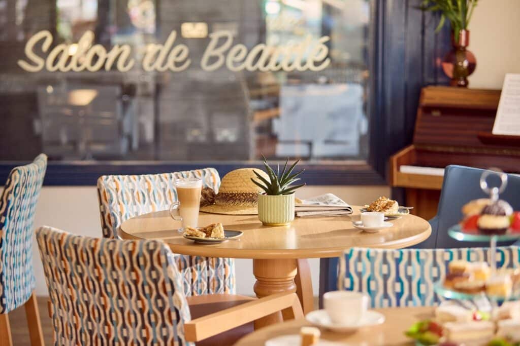 Cosy cafe with coffee, cakes, and decor.