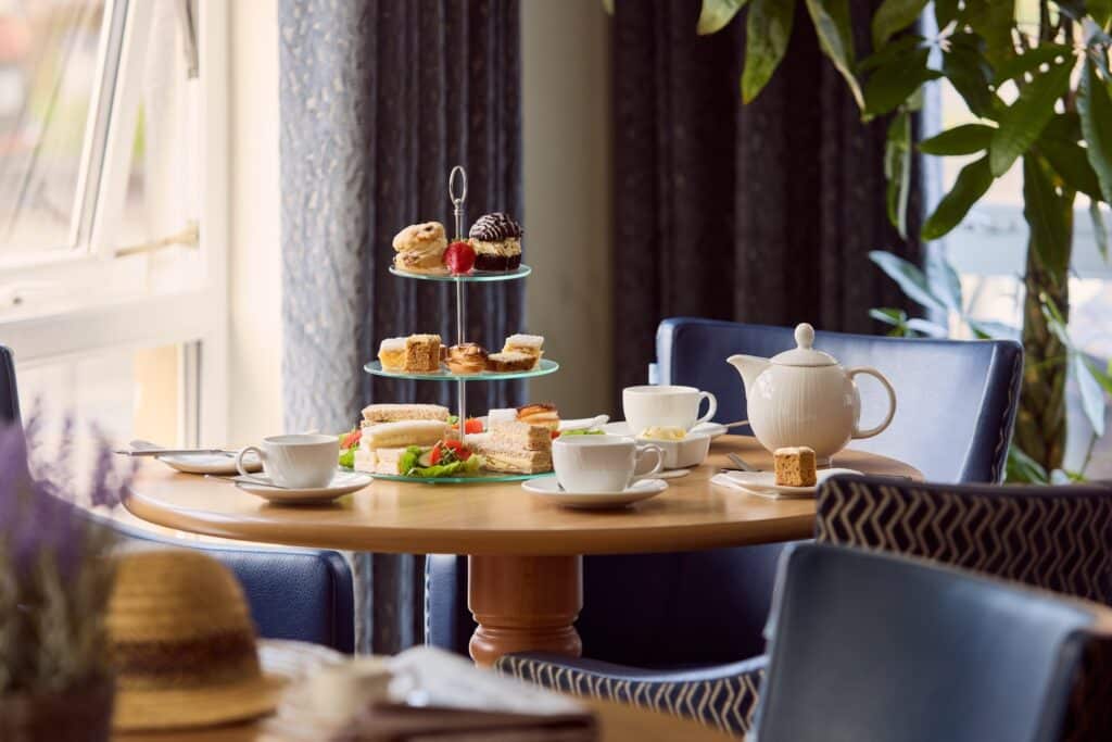 Afternoon tea with pastries and sandwiches on table.