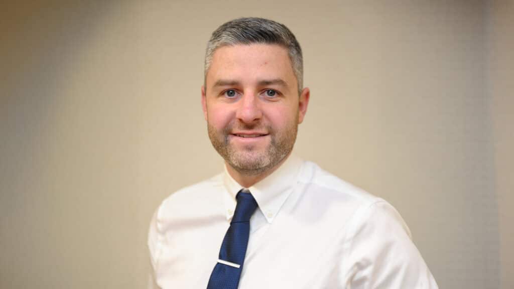 Smiling man in white shirt and blue tie