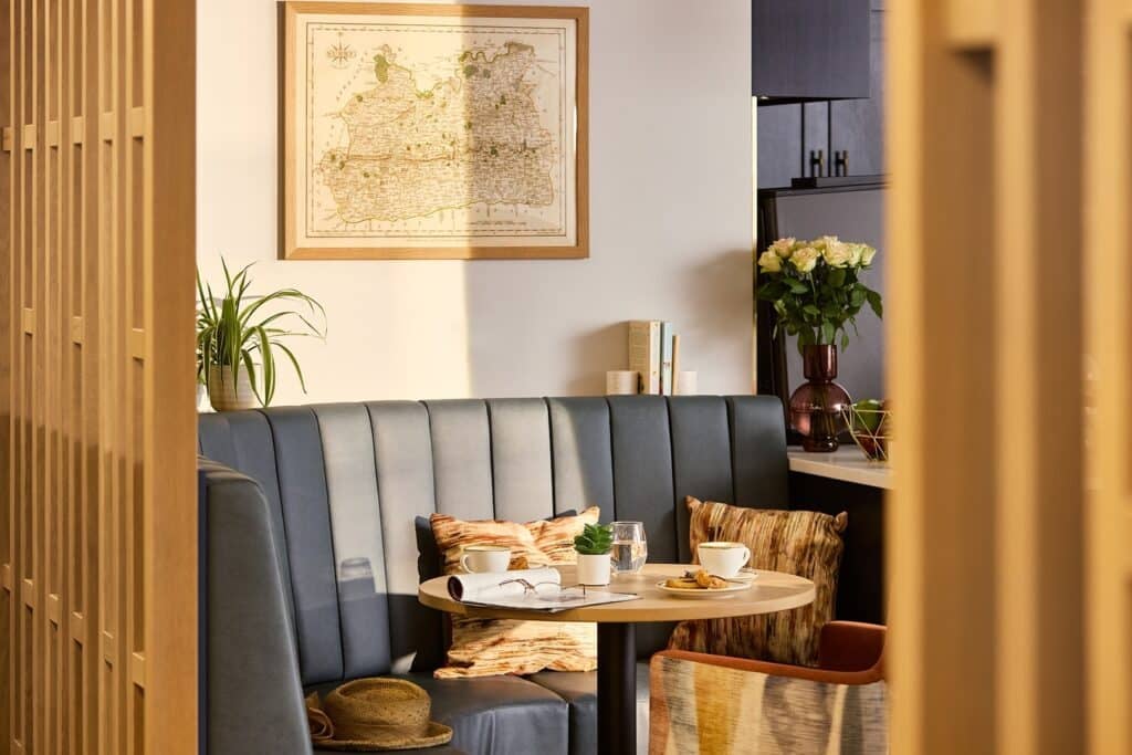 Cosy cafe booth with map artwork and flowers.