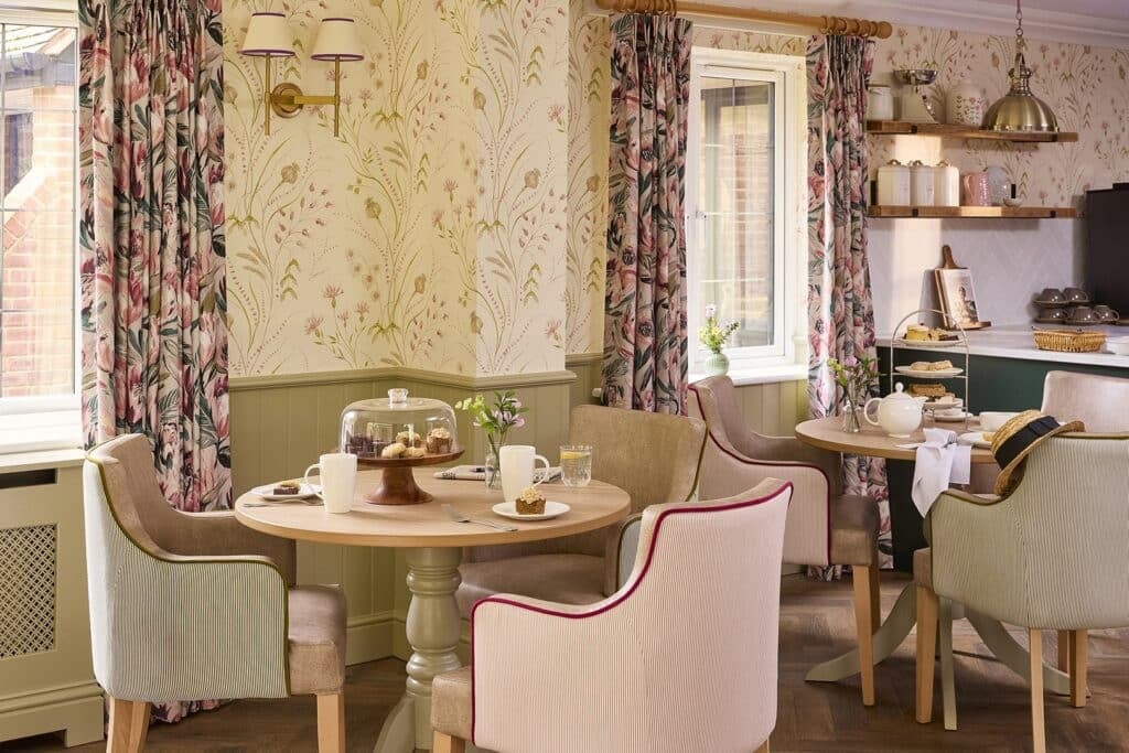 Cosy tearoom with floral decor and pastries.