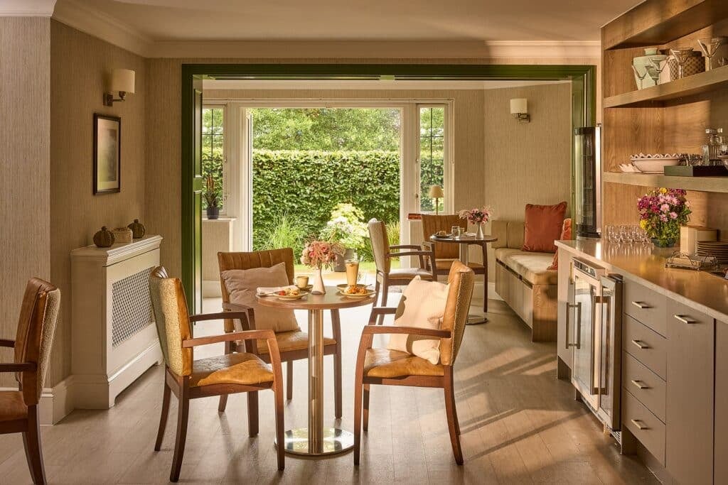 Elegant dining room with garden view and table settings.