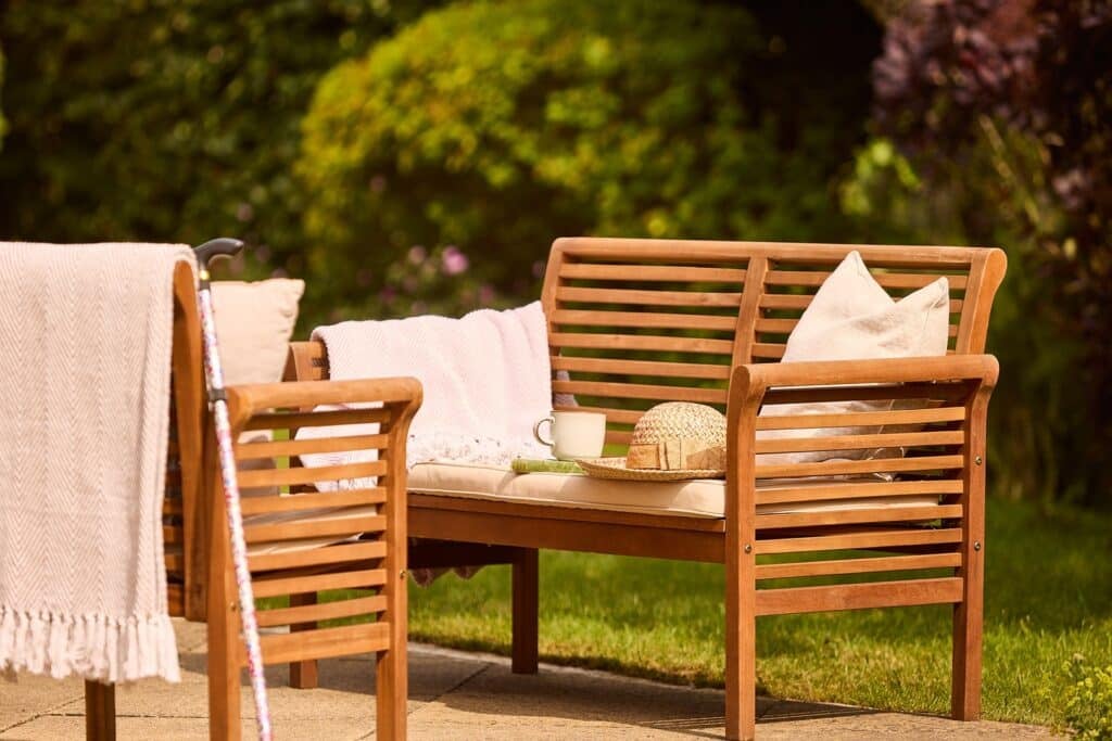 Outdoor wooden seating with hat and cup