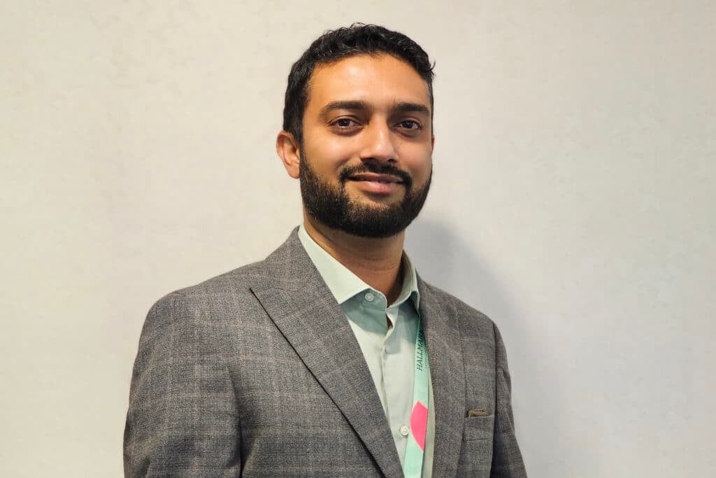 Man in grey suit smiling at camera