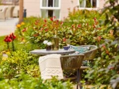Cosy garden table set for two with wine.