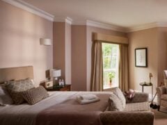 Cosy hotel room with armchairs and a large window.