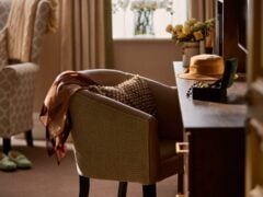 Cosy bedroom corner with armchair and dressing table.