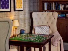Cosy reading nook with puzzle and bookshelves.