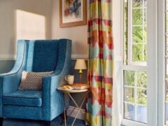 Cosy reading nook with armchair and table.