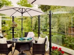 Cosy patio with table, chairs, and parasol.