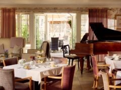 Elegant restaurant afternoon tea setup with grand piano.