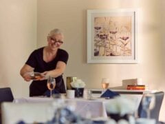 Woman serving rose wine in dining room