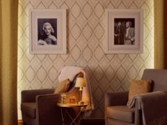 Cosy living room with framed photos and armchairs.