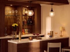 Elegant home bar with drinks and glassware display.