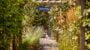 Garden club pathway with flowers and archway.