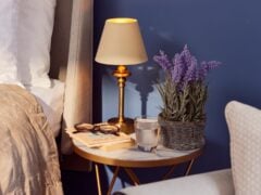 Bedside table with lamp, lavender, and books.