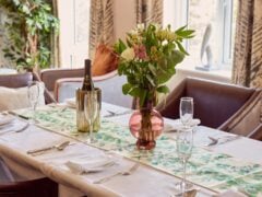 Elegant dining table with flowers and wine bottle.