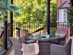 Outdoor patio with wicker furniture and garden view.