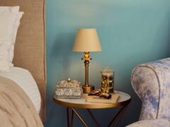 Cosy bedroom nightstand with lamp and decor.