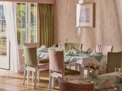 Elegant dining room with set tables and natural light.