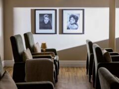 Cinema lounge with framed black-and-white portraits, seats empty.