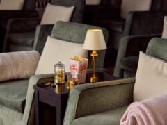Cosy cinema chairs with snacks and lamp.