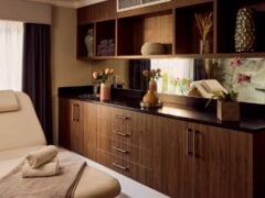 Cosy spa room with wooden cabinets and lounge chair.