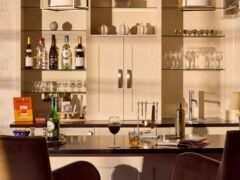 Elegant home bar with drinks and glassware.