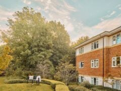 Brick building and garden with trees and benches