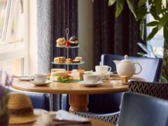 Afternoon tea with pastries and sandwiches on table.
