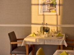 Sunlit restaurant table with wine and decor.