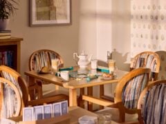 Café table with drinks, pastries, and board game.