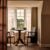 Cosy dining area by bright window with chairs.