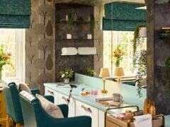 Cosy salon with teal chairs and elegant decor.