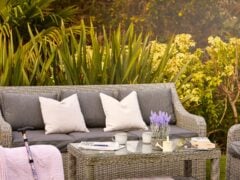 Garden seating area with cushions and coffee table.