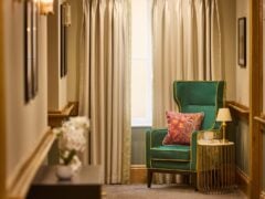 Elegant room with green armchair and curtains.
