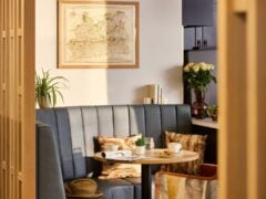 Cosy cafe booth with map artwork and flowers.