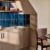 Modern kitchen with teal tiles and dining table.