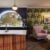 Stylish home bar with seating and floral wallpaper.