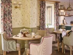 Cosy tearoom with floral decor and pastries.