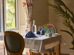 Elegant dining table by window with wine glasses.